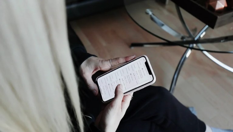 Cleaner reviewing a home cleaning checklist on their phone.