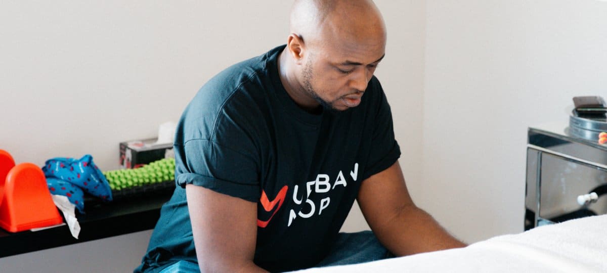 Professional cleaner wearing an Urban Mop shirt making a bed.