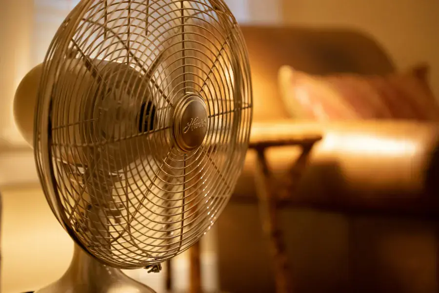 A table fan circulating indoor air in a warm living room.