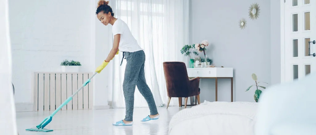 Cleaner wiping the floor in a bright, modern home.
